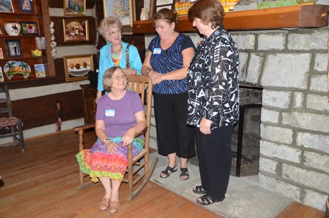 Board members who were involved in the development of the Campbellsville University Log Cabin Art Shop discussed opening day by the fireplace.They are, from left: Linda J. Cundiff, chair of the CU Department of Art; Charlotte Humphress, Margaret Bertram and Cora Renfro. Cundiff, Humphress and Renfro all attended CU in the late 1960s when the art program major was created at then Campbellsville College. Bertram, a member of the Patron of the Visual Arts, was the first to conceive of the idea of the shop in the little log house, according to Cundiff. (Campbellsville University Photo by Linda Waggener)