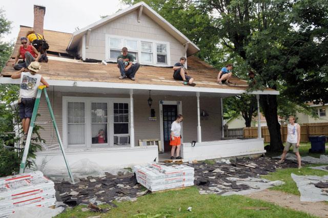 A group of volunteers from Brainerd United Methodist Church in Chattanooga, Tenn., First United Methodist Church in Panama City, Fla., and Mt. Vernon Baptist Church in Boone, N.C., replaces a roof on a house in Glasgow, Ky., during a week-long summer camp with Kentucky Heartland Outreach. (Campbellsville University Photo by Ashley Zsedenyi)