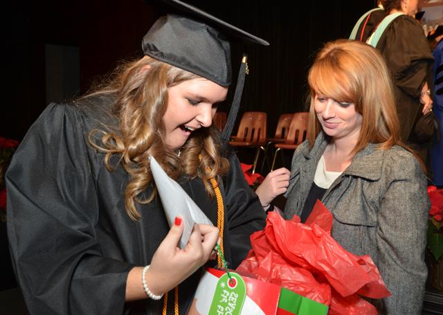  Karlie Neal, right, who spoke at the School of Education pinning before commencement, opens a  gift from McLane Farr. Neal received a bachelor of science degree in elementary education/P-5.  (Campbellsville University Photo by Joan C. McKinney)