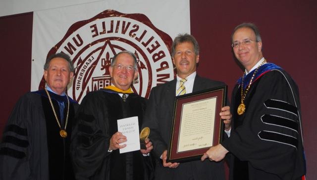 Mark Johnson of Campbellsville, second from left,  chief executive director of Citizens Bank and Trust, receives the community Algernon Sydney Sullivan Award at Campbellsville University's undergraduate commencement. Making the presentation were from left: Dr. Michael V. Carter, president; Dr. Jay Conner, chair of the CU Board of Trustees; and Dr. Frank Cheatham, vice president for academic affairs. (Campbellsville University Photo by Joan C. McKinney)